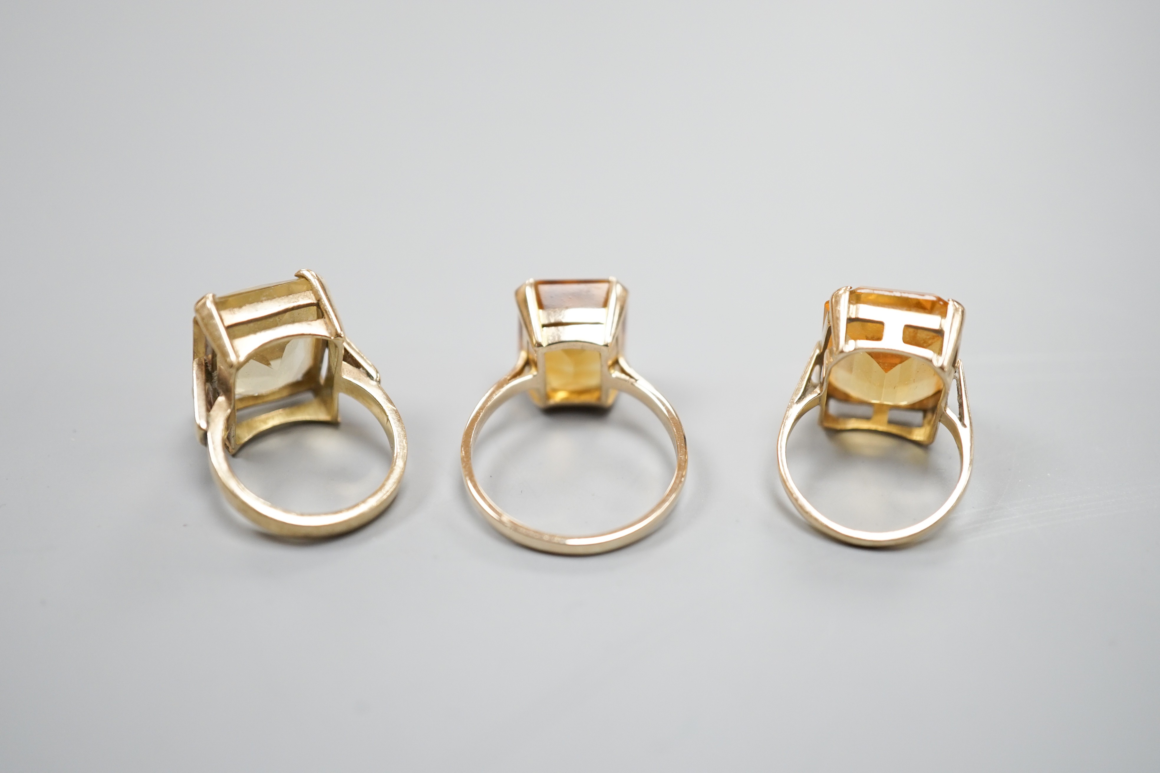 Three yellow metal and citrine set dress rings, one stamped 9ct, gross weight 11.9 grams.